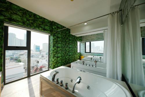 芽庄Napoleon Nha Trang Hotel的一间带三个盥洗盆的浴室和一个大窗户