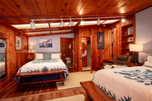沃尔卡诺Aloha Junction Guest House - 5 min from Hawaii Volcanoes National Park的木墙客房的两张床