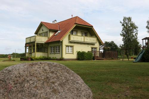 ToolseBeach house Tolsburg with sauna的黄色房子,有红色屋顶和游乐场