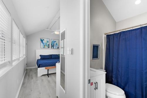 格尔夫海岸Steps to Sand l Ocean views l Smart TVs l Pool的浴室设有卫生间和蓝色的浴帘。