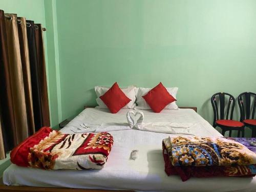 曼达莫尼Bongtel Beach Resort Mandarmani的一张带白色床单和红色枕头的床