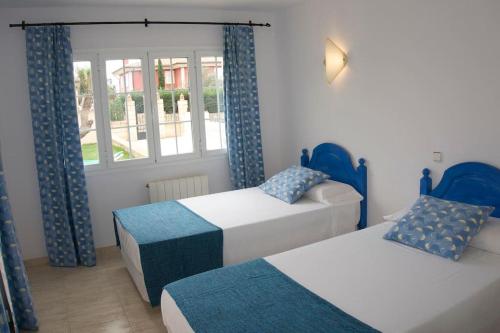 马拉特克西Welcome home. Willkommen. Bienvenidos的一间卧室设有两张床和窗户。