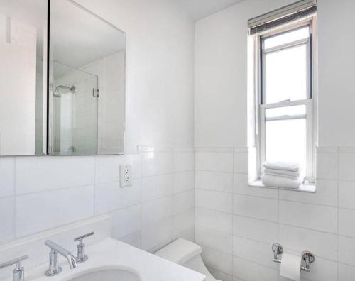 纽约Lovely 4 BR in NYC!的白色的浴室设有水槽和镜子