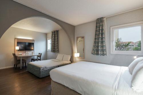 马赛马赛议会宫基里亚德酒店 - 自行车馆 的一间卧室配有一张床和一张桌子及椅子