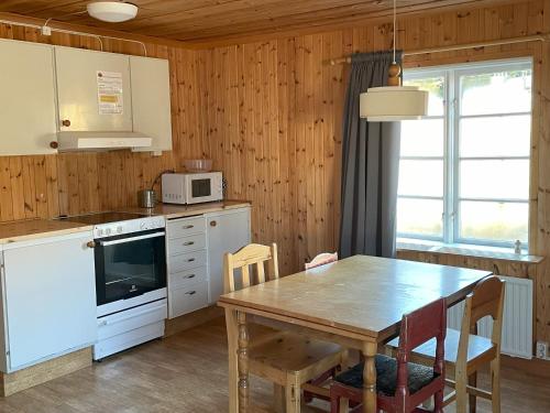 UlvöhamnSandvikens Fiskeläge Ulvön的厨房配有桌子和木墙