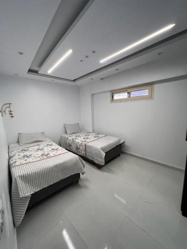 艾因苏赫纳بورتو السخنه -Hotel Porto vib的一间卧室设有两张床,其中设有窗户。