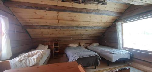 JörnGemütliche Blockhütte mit Außentoilette und Badezimmer im Haupthaus的小木屋内带两张床的房间