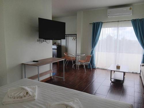 陶公โรงแรมนราพัตรา的酒店客房设有床、桌子和电视。