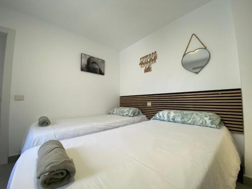 大加那利岛拉斯帕尔马斯Holiday Home & Rooftop Lounge的白色墙壁客房的两张床