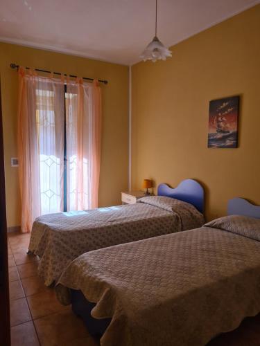 圣安蒂奥科Casa in Centro的带窗户的客房内的两张床