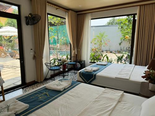 宁平Azalea Tam Coc Ninh Bình的带大窗户的客房内的两张床