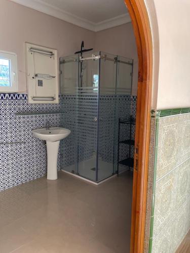 MelîyechVilla Casa Jasmin的一间带玻璃淋浴和水槽的浴室