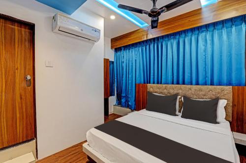 新德里Hotel Royal Pacific Near Delhi International Airport的一间卧室配有一张蓝色窗帘的床