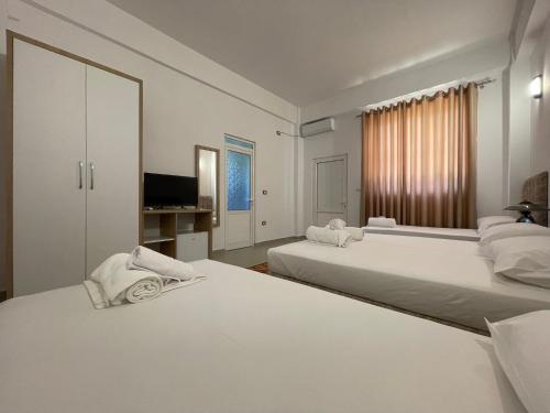 培拉特Villa Deart Berat的一间白色卧室,配有两张床和电视
