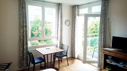 勒特雷波尔Voiles et Terrasses Le Treport的一间带桌椅和窗户的用餐室