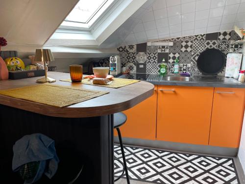维特雷Studio VITRÉ CENTRE的厨房配有橙色橱柜和台面