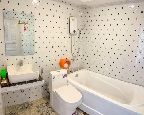 Phumĭ Véal SbovMean Mean Bungalow的浴室配有白色浴缸、卫生间和水槽。