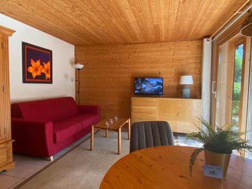 拉夏贝尔德邦达La Joly - ChaletYap的客厅配有红色的沙发和桌子