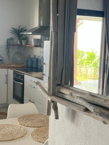 法沃内Favone Mini Villa Playa del Oro的厨房配有桌椅和窗户。