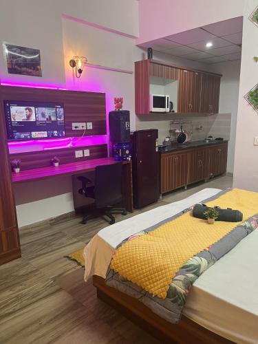 大诺伊达Bella Dreamy near expo mart greater Noida的一间卧室配有一张床和一张书桌及电视