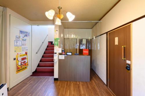 湖西市OYO Ryokan Hamanako no Yado Kosai - Vacation STAY 38804v的一个带楼梯的办公室走廊和前台