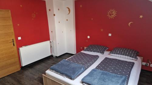 克拉尼Hiša Bizjak的一间卧室设有两张床和红色的墙壁
