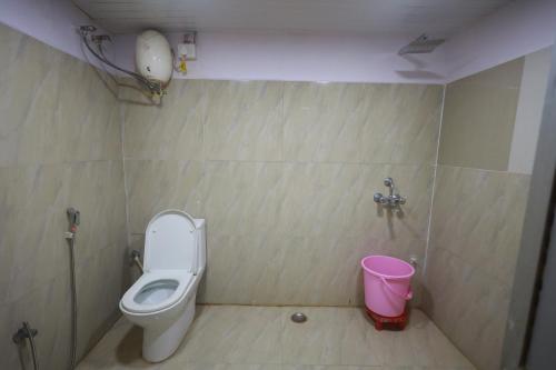 巴特那Raj Resort的一间带卫生间和粉红色桶的浴室