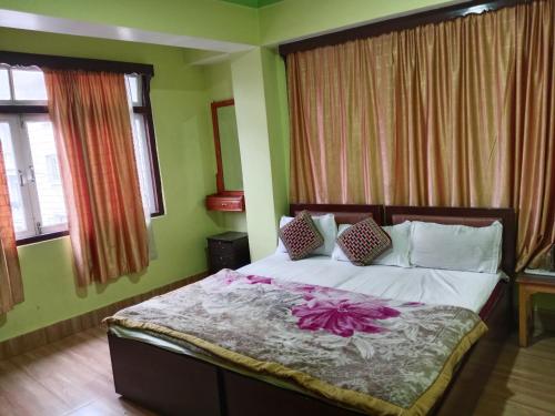 甘托克Zimkhang Guesthouse的一间卧室,床上有粉红色的鲜花