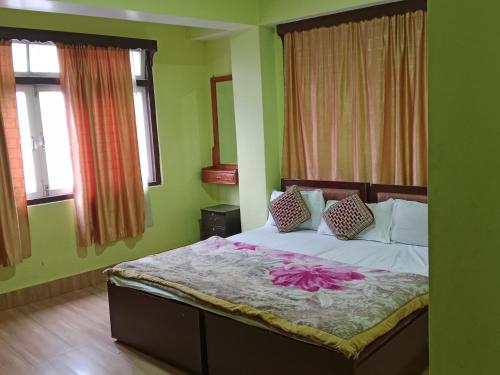 甘托克Zimkhang Guesthouse的绿色墙壁和窗户的客房内的一张床位