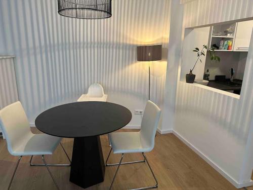 杜塞尔多夫Appartement DUS的一张黑桌子、白色椅子和黑桌子