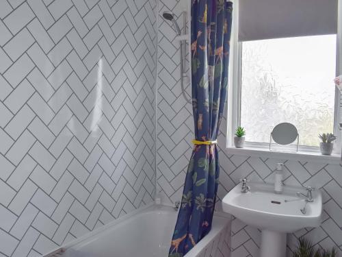 OchiltreeMuirston Farmhouse的浴室配有淋浴帘和盥洗盆。