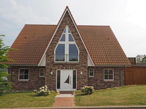 沃伦伯格Ferienhaus Sandra的砖屋,有三角形的屋顶和白色的门