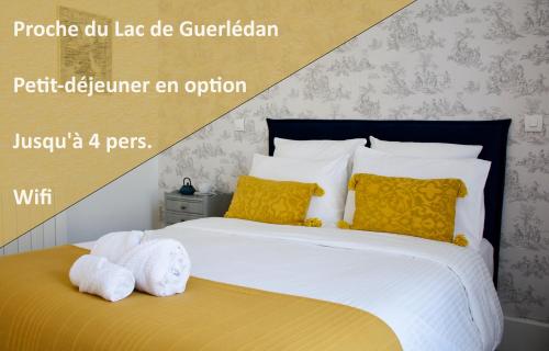 CaurelValfrescos - Lac de Guerlédan的一间卧室配有黄色和白色枕头的床