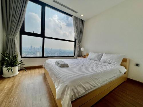 河内One bedroom in Vinhomes GreenBay Hanoi的一间卧室设有一张大床和大窗户