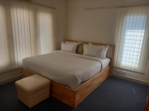 班加罗尔Windfall Service Apartment的一间卧室设有一张大床和两个窗户。