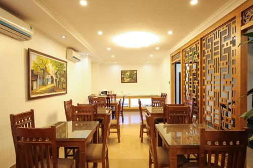河内Bạch Dương Hà Nội Hotel的一间在房间内配有桌椅的餐厅