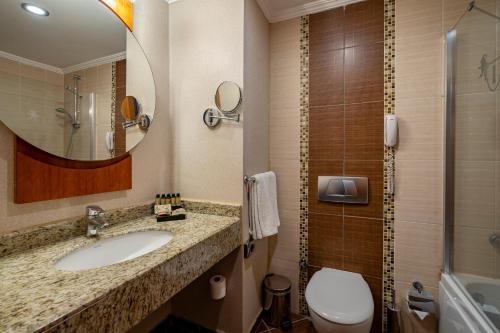 贝尔迪比Sunland Resort Beldibi的一间带水槽、卫生间和镜子的浴室