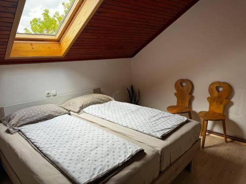 采尔克尼察Rooms Apartma Cerknica的一间卧室配有一张带窗户和两把椅子的床