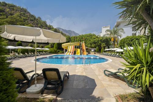 贝尔迪比Sunland Resort Beldibi的一个带椅子和滑梯的游泳池