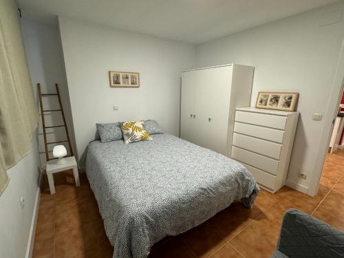 卢安科apartamento luanco playa的一间卧室配有一张床、梳妆台和梯子