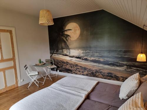 Saint-Amand-JartoudeixBon Chez Nous的一间卧室,上面有一张大海滩画