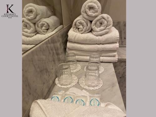 基拉尼凯尔拉尼科特酒店的浴室柜台配有毛巾和一堆毛巾