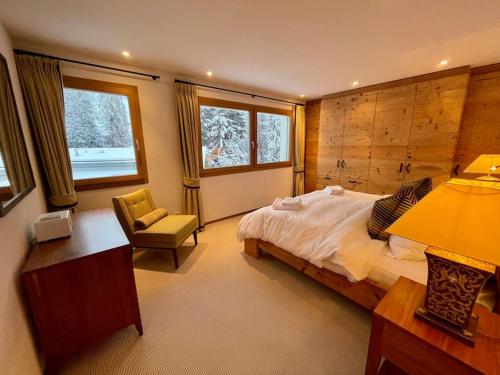 弗利姆斯Elegant apartment in Flims close to Lake Caumasee的一间卧室配有一张床、一张桌子和一把椅子