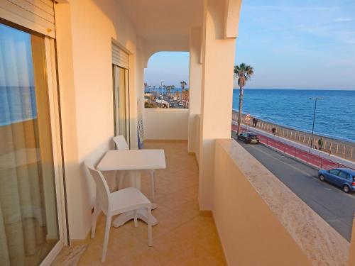 文蒂米利亚卡力酒店的阳台配有桌子,享有海景。