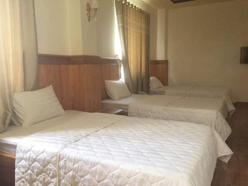De Dang (1)Kbang的酒店客房,配有两张带白色床单的床