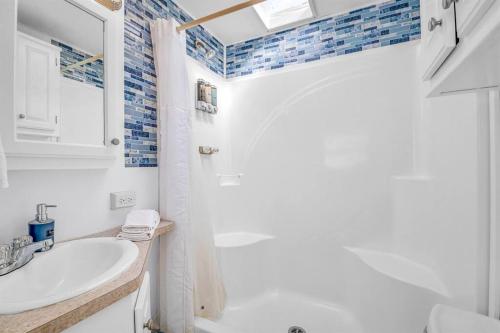弗吉尼亚海滩Sea La Vie Beach Cottage的白色的浴室设有水槽和镜子