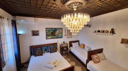 培拉特Guesthouse Alvaro Kadiu的客房设有两张床和吊灯。