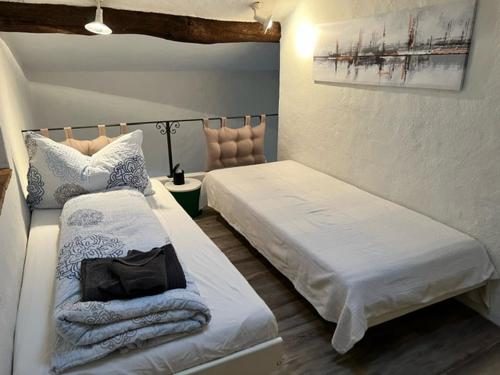 卡斯拉诺Caslano: 2.5 Zi-Dachwohnung im rustikalen-modernen Stil的一间卧室配有两张床和椅子