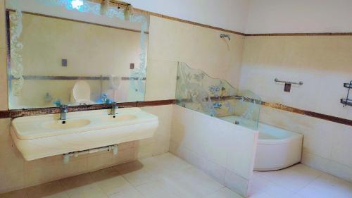 卡拉奇Clifton Lodge Boutique Hotel的一间带水槽、浴缸和卫生间的浴室