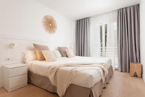 坎皮卡福特Bauló Mar Apartments的白色的卧室设有一张大床和一个窗户